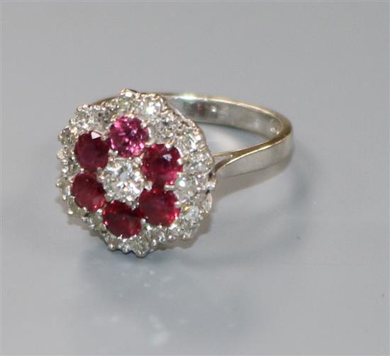 A modern 18ct white gold, ruby and diamond flower head cluster ring, size M.